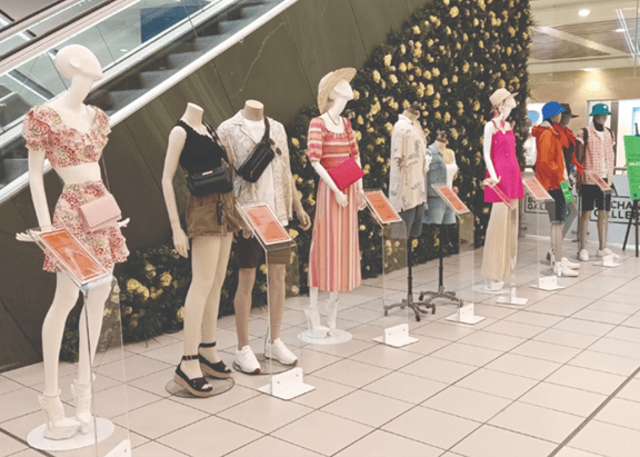 10 mannequins, both male and female, dressed in trendy festival fashion lined up against the flower wall in shopping centre, Buchanan Galleries in Glasgow, Scotland.